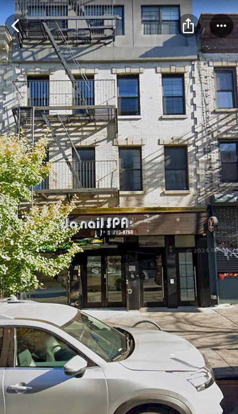 A white car is parked in front of a building with a sign that reads "L'aile Spa".