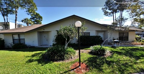 A house with a lawn and a lamp post in front.