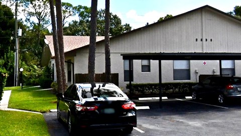 A black car is parked in front of a building.