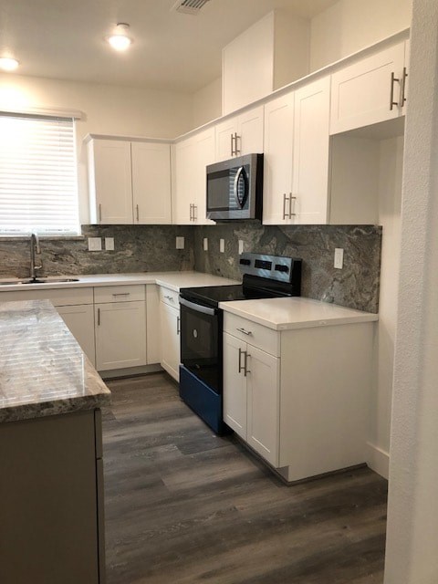 A kitchen with white cabinets and a granite countertop.
