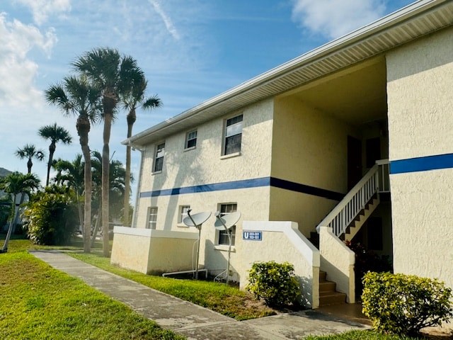 A building with a blue stripe on the side has a sign that says "UE".