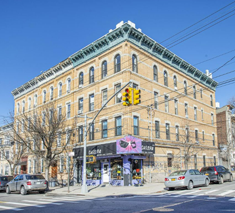 A street view of a building with a pink mural on the front and a sign that says "Chas Pa Shisha".