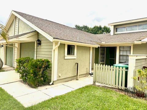 A house with a green door and a white picket fence.