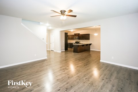 A spacious room with a wooden floor and a ceiling fan.