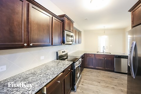 A kitchen with wooden cabinets and a granite countertop.