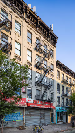 A building with a red awning and a closed shuttered window.