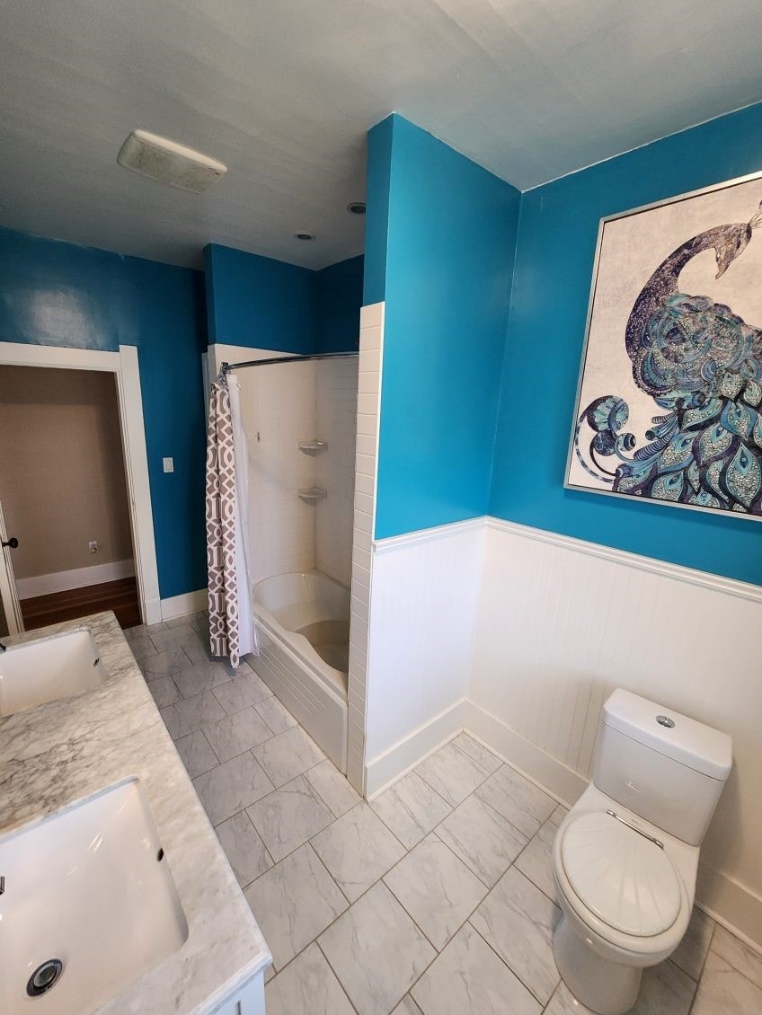 A bathroom with blue walls and a marble sink.