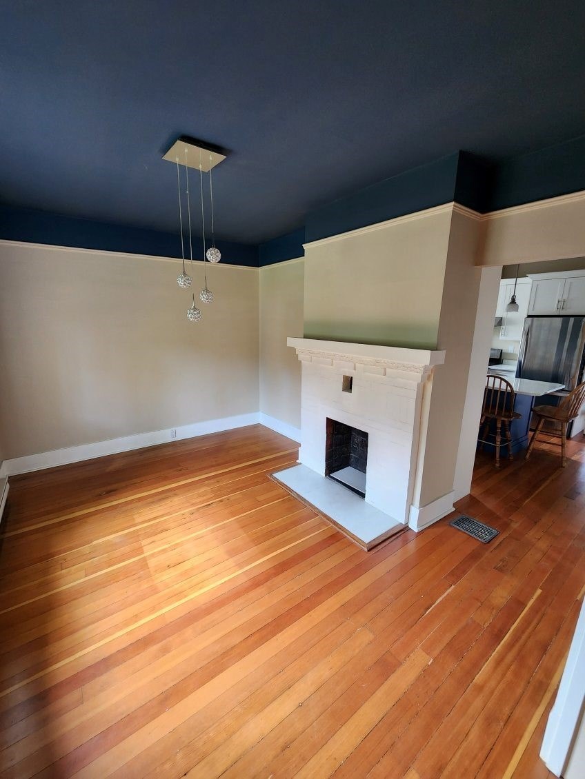 A room with a fireplace and wooden floors.