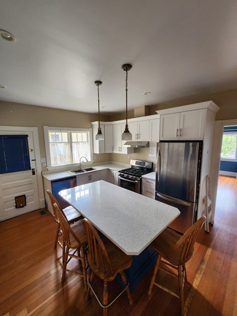 A kitchen with a table and chairs.