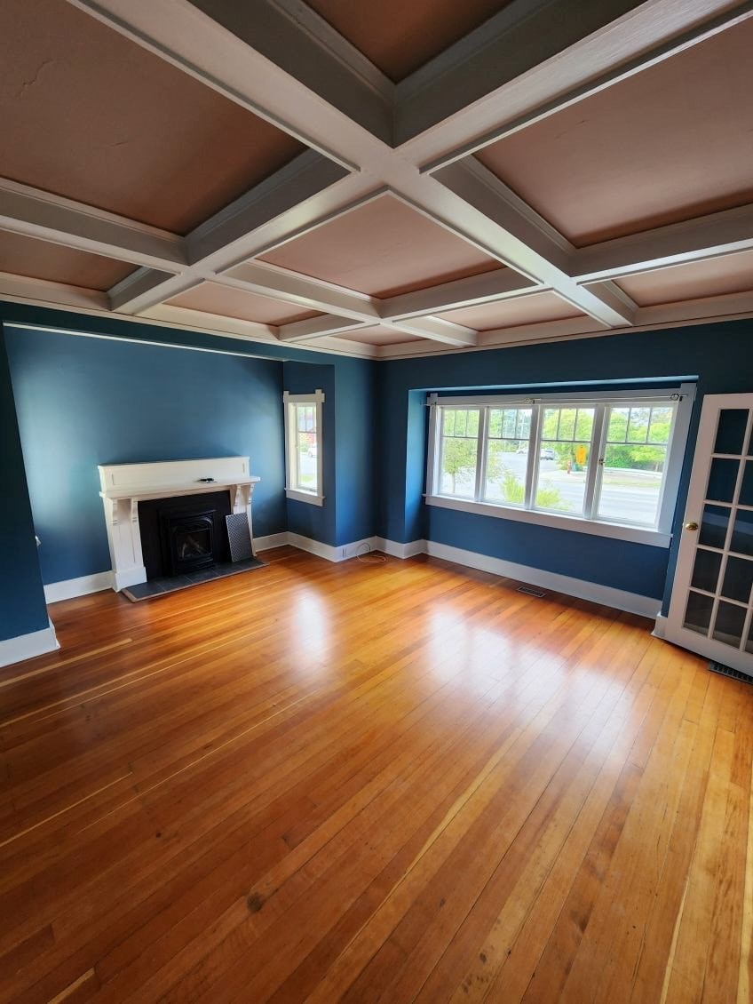 A room with a fireplace and wooden floors.