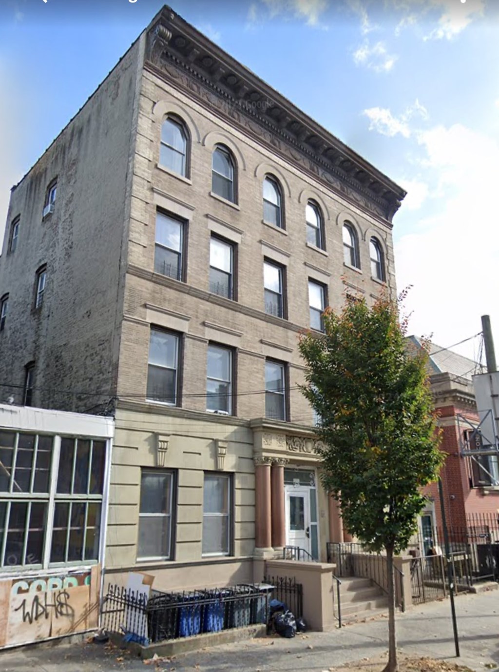 A brown building with a tree in front of it.