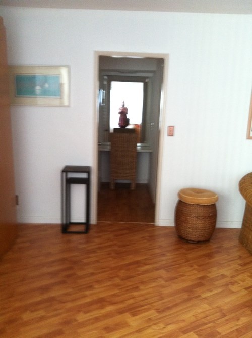 A hallway with a doorway leading to a balcony.