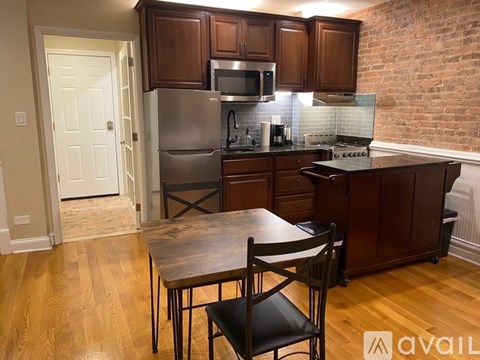 A kitchen with a table and chairs in front of it.