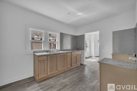 A kitchen with wooden cabinets and a countertop is available for rent.