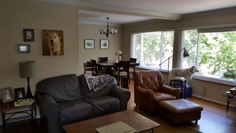A living room with a black couch and a brown leather chair.