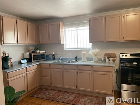 A kitchen with wooden cabinets and a stainless steel oven.