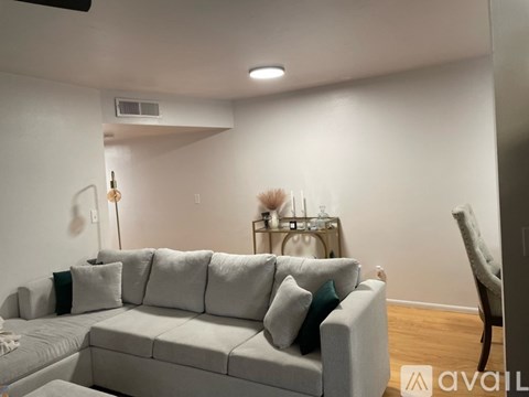 A living room with a grey couch and a wooden floor.