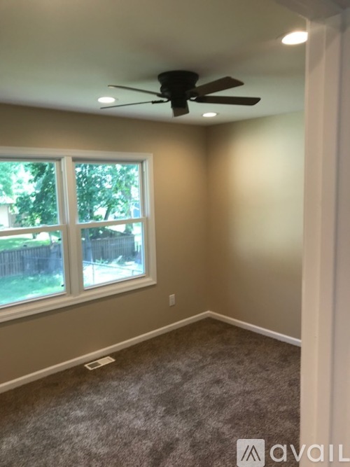 A room with a ceiling fan and a window.
