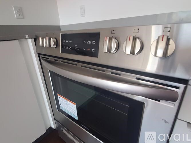 A stainless steel oven with a digital display and control knobs.