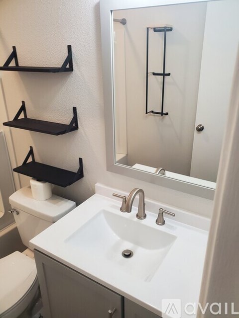A white sink in a bathroom with a mirror and toilet.