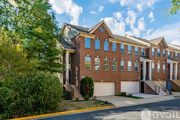 A bathroom with a toilet, sink, mirror, and a trash can.