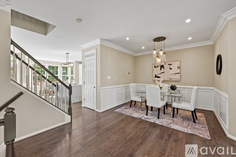 A dining room with a white table and chairs.