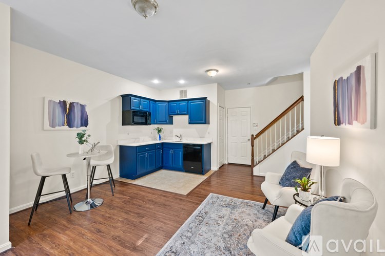 A kitchen with blue cabinets and a white chair.