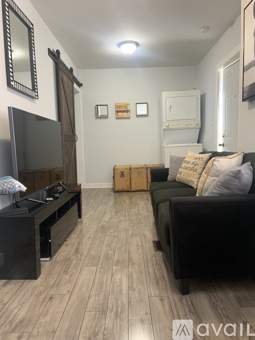 A bedroom with a bed, a mirror, and a trash can.