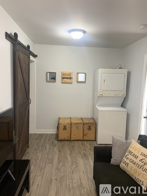 A room with a couch, a television, and a wall-mounted cabinet.