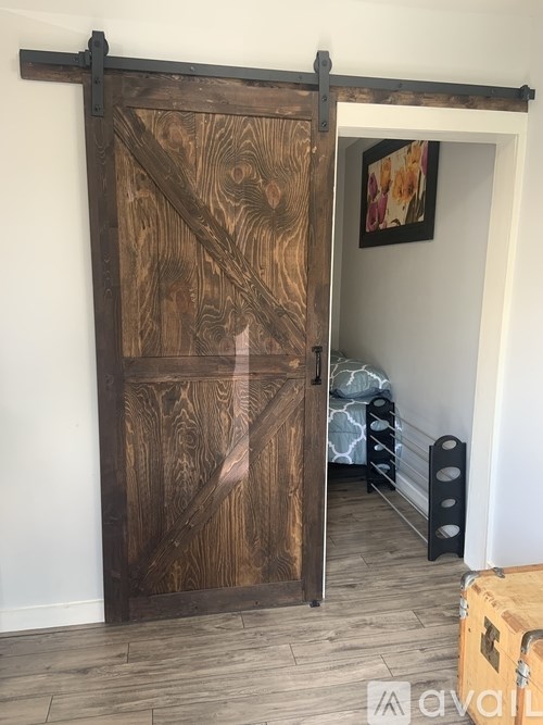 A wooden door with a black handle is open.
