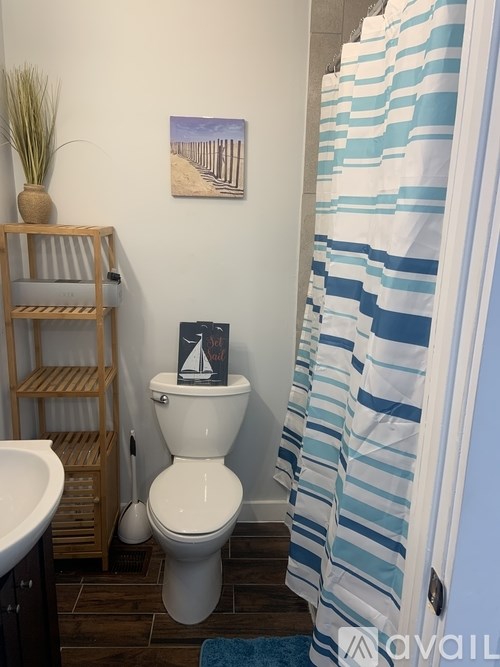 A white toilet sits next to a white sink in a bathroom.