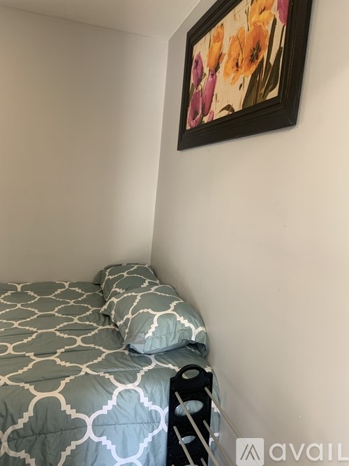 A bed with a grey and white patterned duvet cover and a black and white pillow case.