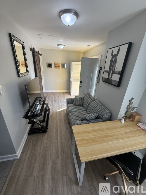 A black couch with two pillows sits in a living room.