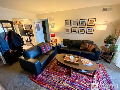 A living room with a black couch and a coffee table.