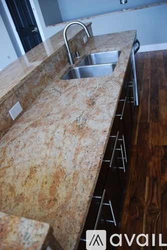 A kitchen counter with a sink and a faucet.