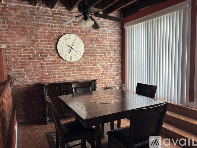 A dining room with a brick wall and a wooden table.