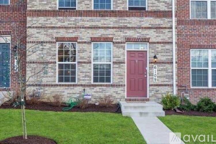 A red door is on the front of a brick building.