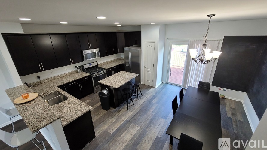 A modern kitchen with black cabinets and a granite countertop.