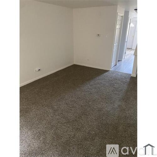 A room with a carpeted floor and white walls.