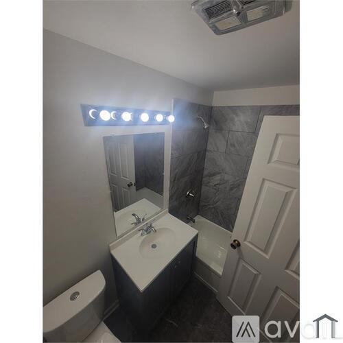 A bathroom with a white sink and a mirror above it.