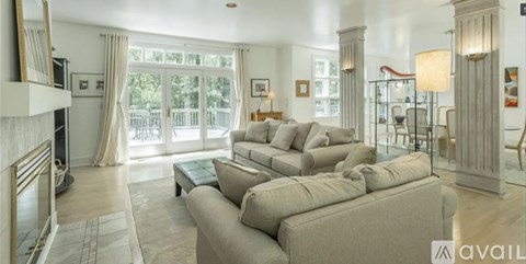 A living room with a large couch and a fireplace.