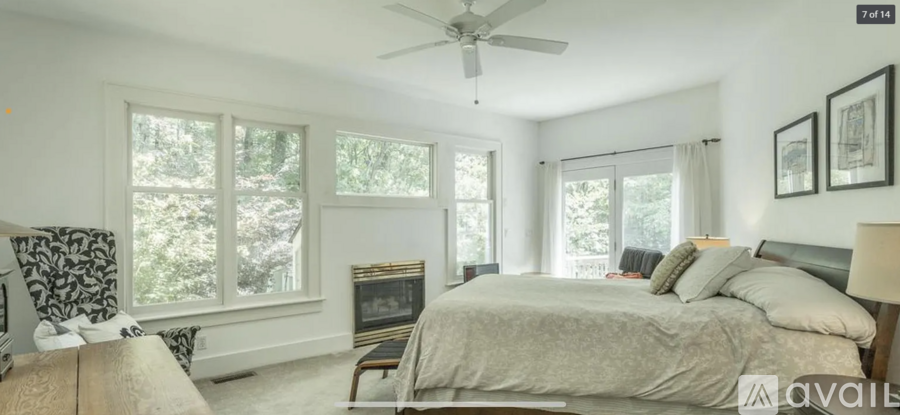 A bedroom with a large bed and a fireplace.