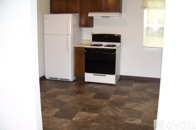 A kitchen with a white fridge and black stove.
