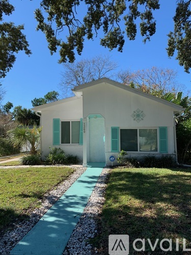 A white house with a green door and windows.