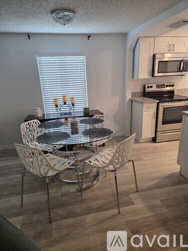 A room with a table, chairs, and a gym equipment.