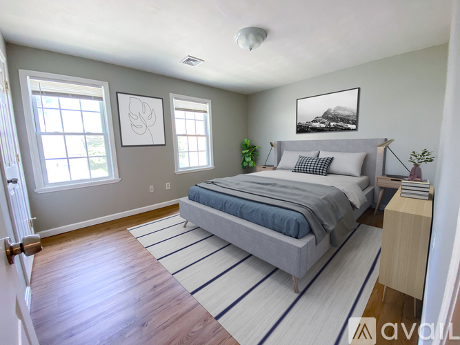 A bedroom with a bed, a window, and a painting on the wall.