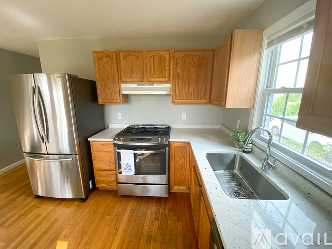 A kitchen with wooden cabinets and a stainless steel refrigerator.