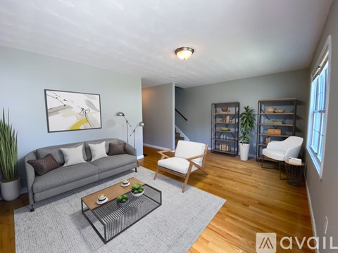 A living room with a grey couch, a coffee table, and a painting on the wall.
