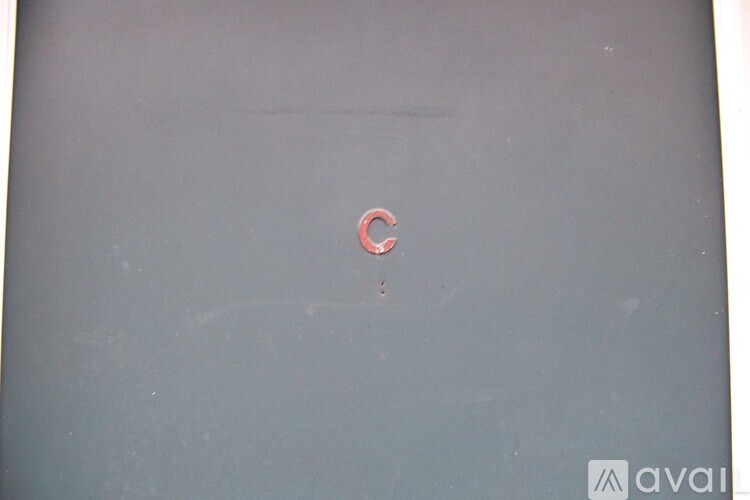 A small red letter C is on a grey background.