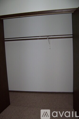 A room with a white wall and a brown carpet.